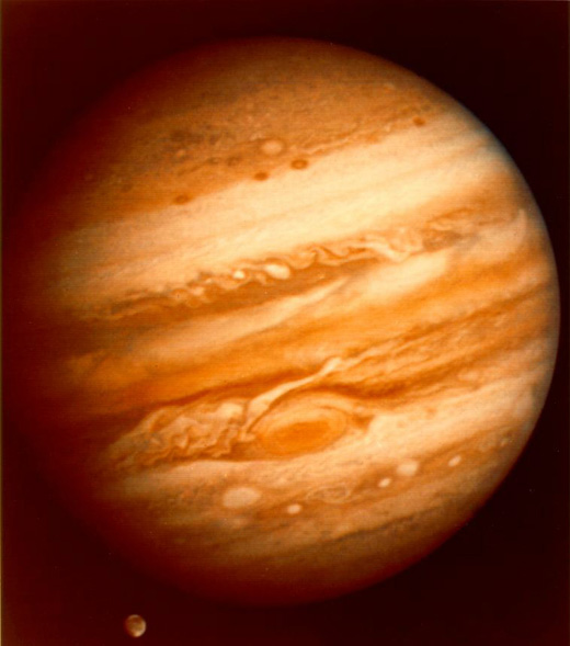 Imagen de Jpiter con su caracterstica distribucin en bandas de las masas de gases, y la Mancha Roja en la parte inferior. Por debajo se puede ver a Ganmedes transitando junto al planeta.